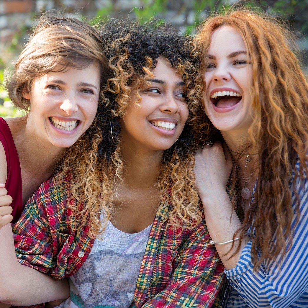 Group of women with different curl types hugging.